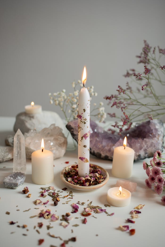 productos A serene arrangement of candles, crystals, and dried flowers creates a calming atmosphere.